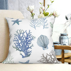 short-pile plush polyester pillow cover with blue coral, shells and starfish, shown on a cream sofa