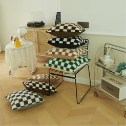 Assorted square and lumbar checkerboard faux fur pillow covers in a room