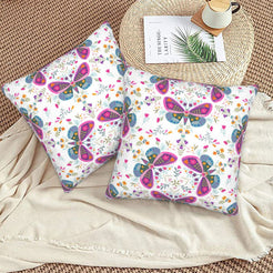 Folk butterfly velvet pillow covers with white circular butterfly motifs, styled on a woven chair