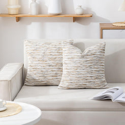chenille-textured polyester pillow covers with cream, gray and ochre horizontal stripes, arranged on a cream sofa