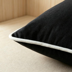Close-up of piped edge and soft surface on velvet pillow cover with black velvet with white piping