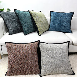 Chenille-textured polyester pillow covers with charcoal, teal, olive and blue covers with black trim, styled on a white sofa