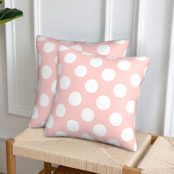 Blush pink polka dot velvet pillow covers styled on a woven chair