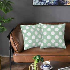 Mint green polka dot velvet pillow covers styled on a sofa