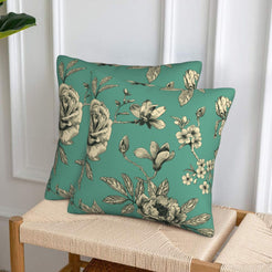 Set of two green velvet pillow covers with roses and magnolia, styled on a woven chair