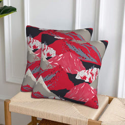 Set of two velvet pillow covers with red, black and gray mountains, styled on a woven chair