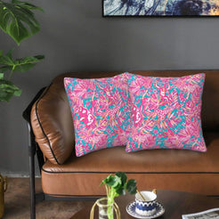 Velvet pillow covers with pink and teal tropical foliage, styled on a sofa