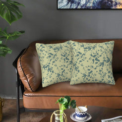 Bohemian velvet pillow covers with blue botanical silhouettes on pale green, styled on a brown leather sofa