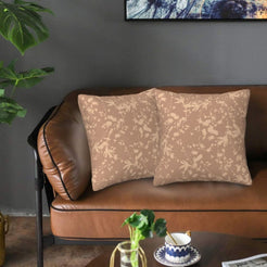 Bohemian velvet pillow covers with taupe botanical silhouettes on blush, styled on a brown leather sofa