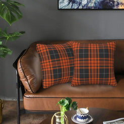 Fall velvet pillow covers with dark charcoal and orange tartan, styled on a brown leather sofa