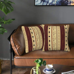 Velvet pillow covers with cream and burgundy vertical geometric panels, styled on a leather sofa