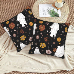 Halloween velvet pillow covers with black ghosts, bats and flowers, styled on a woven chair