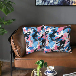 Velvet pillow covers with pink, blue and black camouflage, styled on a sofa