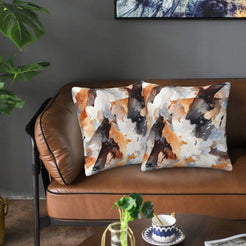 Velvet pillow covers with orange and black abstract camouflage, styled on a sofa