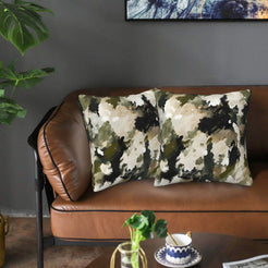 Velvet pillow covers with watercolor olive and black camouflage, styled on a sofa