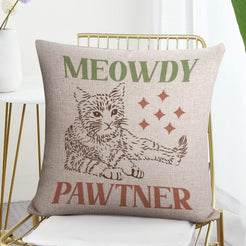 Linen-look pillow cover with Meowdy Pawtner cat illustration, shown in a flat lay