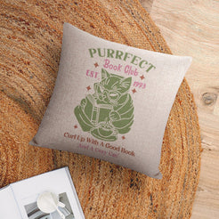 Linen-look pillow cover with Purrfect Book Club cat illustration, styled on a chair