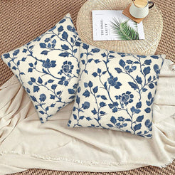 Block-print-inspired velvet pillow covers with navy rose vines, styled on a woven chair
