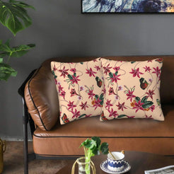 Velvet pillow covers with burgundy flowers and butterflies on blush, styled on a brown leather sofa