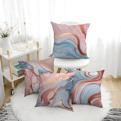 Four short-pile plush pillow covers with blush, blue and rose gold marble designs, styled in a bright room