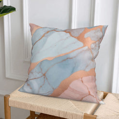 Short-pile plush pillow cover with peach, blush and blue marble designs, styled on a woven chair