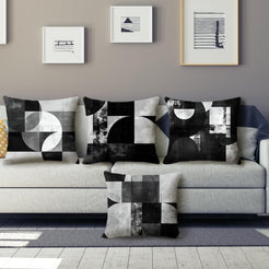 Short-pile plush pillow covers with black and gray Bauhaus-style geometry, styled on a gray sofa