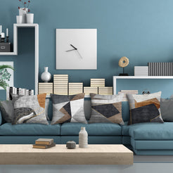 Short-pile plush pillow covers with gray, brown and black abstract geometry, styled on a blue sectional