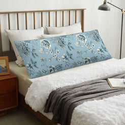 Repeating floral light blue body pillow cover styled across a bed