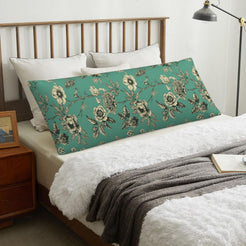 Repeating floral green body pillow cover styled across a bed