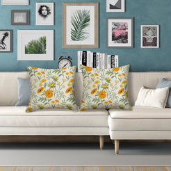 Water-resistant pillow covers with cream orange and yellow meadow flowers, styled on a white sofa
