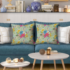 Water-resistant pillow covers with sage pink and blue wildflowers, styled on a teal sofa