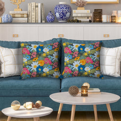 Water-resistant pillow covers with dark green multicolor meadow flowers, styled on a teal sofa