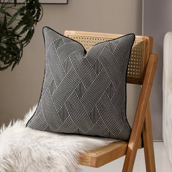 Black and white herringbone jacquard pillow covers styled on a chair