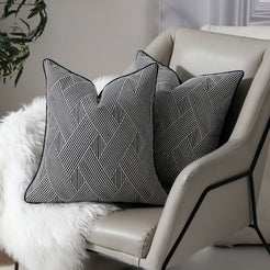 Black and white herringbone jacquard pillow covers styled on an armchair
