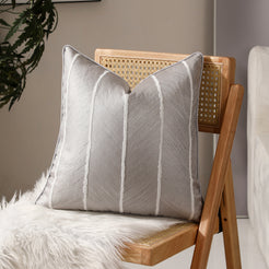 Silver vertical stripe jacquard pillow covers styled on a chair