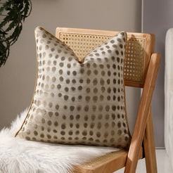Cream and gold dot jacquard pillow covers styled on a chair