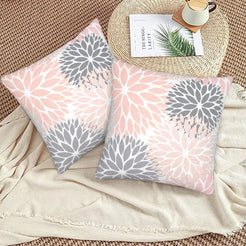 Blush and gray dahlia pattern velvet pillow covers styled on a woven chair