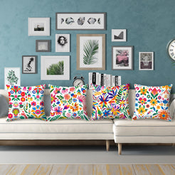 Short-pile plush pillow covers with bright Mexican-inspired floral patterns on white, styled on a cream sectional