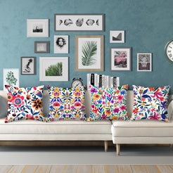 Short-pile plush pillow covers with bold multicolor folk floral patterns on white, styled on a cream sectional