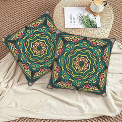 Dark green and peach geometric mandala design velvet pillow covers styled on a woven chair