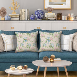 Water-resistant linen-look polyester pillow covers with scattered hydrangeas on cream, styled on a blue sofa