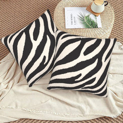 Velvet pillow covers with black and white wide zebra stripes, styled on a beige sofa