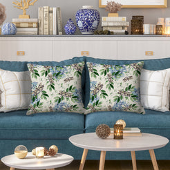 Outdoor water-resistant linen-look polyester pillow covers with birds and blue flowers, styled on a blue sofa