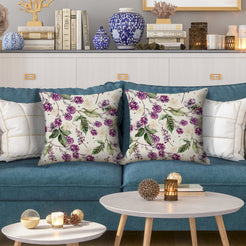 Outdoor water-resistant linen-look polyester pillow covers with birds and purple berries, styled on a blue sofa