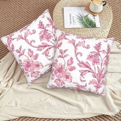 Pink toile velvet pillow covers with pink scrolling floral vines on white, styled on a woven chair