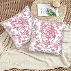 Pink toile velvet pillow covers with pink ornate floral bouquets on white, styled on a woven chair