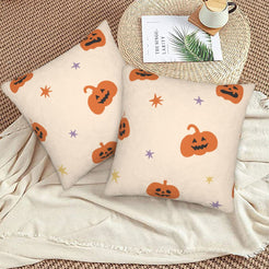 Halloween pillow covers with cream orange jack-o-lanterns, styled on a woven chair