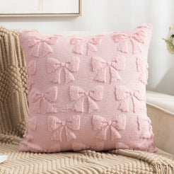 Quilted polyester pillow covers with raised pink bows, styled on a cream sofa