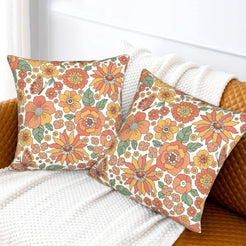Set of two velvet pillow covers with cream dense retro autumn floral pattern, styled on a sofa