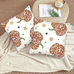 Set of two velvet pillow covers with cream plaid pumpkins and stars, styled on a woven chair